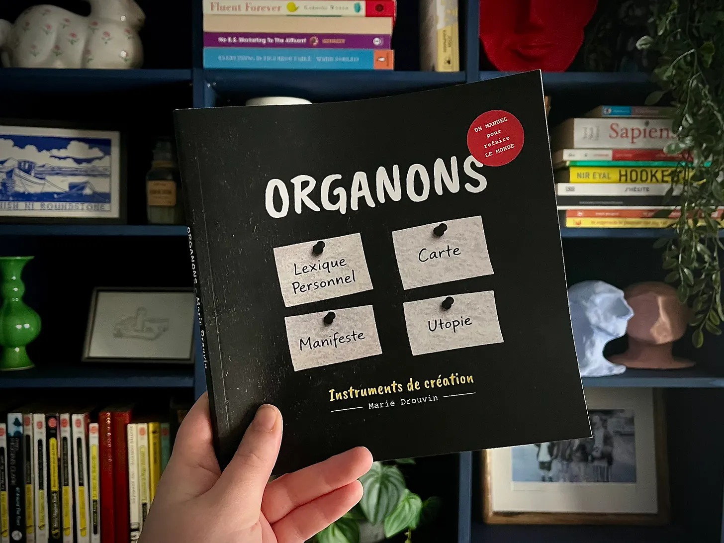 The Organons book held in front of a bookshelf